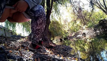 BBW in leggings pissing by the lake in a park