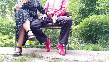 Hot MILF jerks off a big dick into a glass in the park on a bench