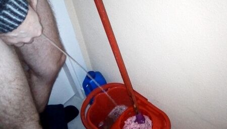 John is taking a piss into the cleaning bucket