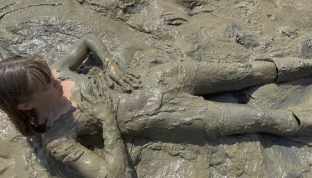 Estuary mud girl playing in the nude