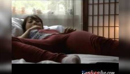 Asian girl masturbates on her bed.