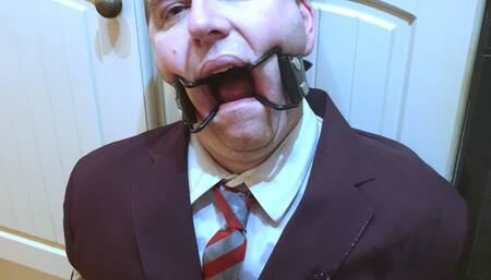 Strap on used on ring gagged man in adult school uniform