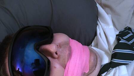 Edging a man in adult school uniform tightly gagged and chained to the bed