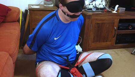 Man in football kit bound and gagged cross-legged by woman 3