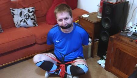 Man in football kit bound and gagged cross-legged by woman 4