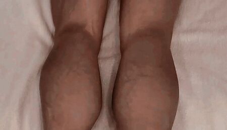 Iron Ivy lying on a mattress flexing her leg muscles