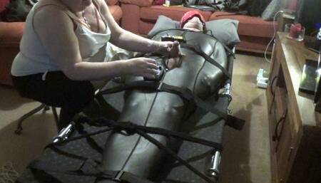 E-stim experimentation and polishing on a helpless man strapped down in a neoprene sleepsack