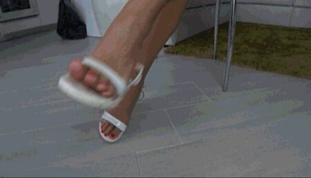 Dangling and toe wiggling in white summer sandals a