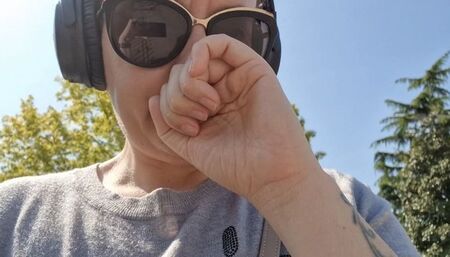 Sneezing on the street with a runny nose and expensive headphones avi