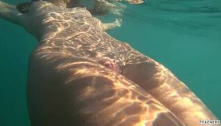 Nude model swims on a public beach in Russia