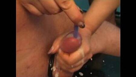 Mistress inserting toothrbush in a guy's cock while she jerks and makes him cum