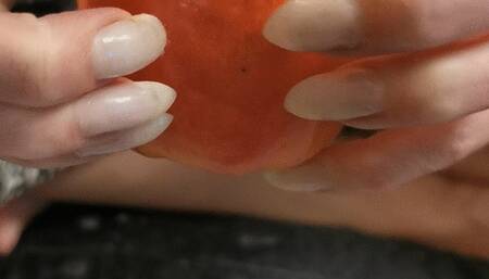 Pointy natural nails clawing apple