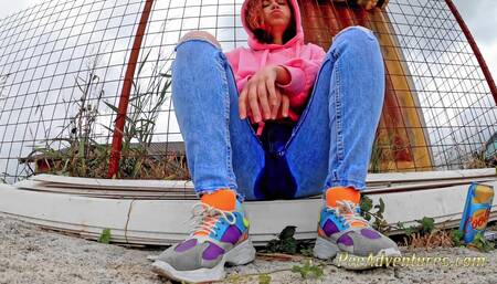 Pissing trough her tight blue jeans outdoor