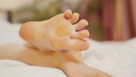 Callused feet resting in bed (720p)