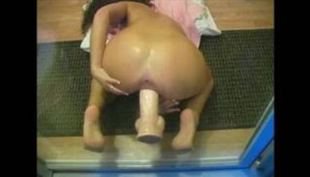 Wife fucks dildo against glass door while husband watches from outside