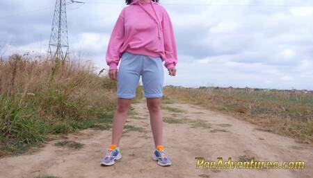 Hipster redhead changes wet clothes and pee outdoor - Girl with a hoodie pee trough her jeans