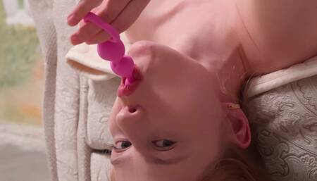 Sofa lies upside down and plays with pink balls