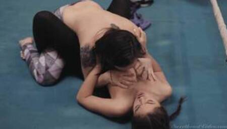 Sinn S and Kendra S in a wrestling ring in a strap-on dildo scene together