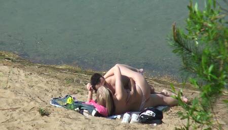A couple of young nudists are spied on while having sex and enjoying themselves on the beach