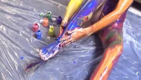 Sexy petite bitch hand paints her skin on the floor