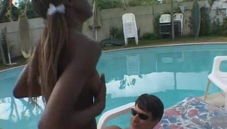Black babe rides a hard white cock next to the pool