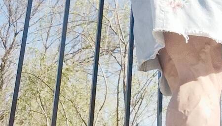 In jean skirt and tye dye sneakers