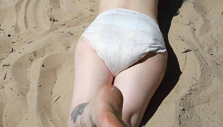 Diapered Nicole spends free time on the beach