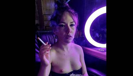 A beautiful lady smokes a cigarette