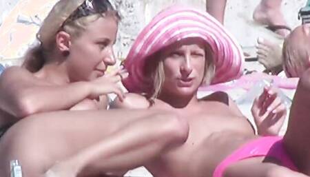 Topless girls are being filmed by a voyeur at this public beach