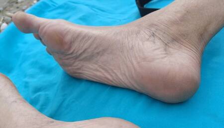 Close-up of my heels, soles and feet on the river beach