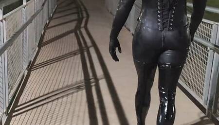 Tania in latex walks across the bridge