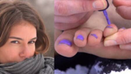 Teresa applies nail polish to her toes outside in the snow - 12400