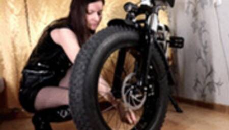 Biker girl deflates a tire
