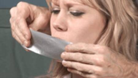 Bare-breasted little blonde Mallory Martini wriggles frog-tied and tape-gagged on the floor!