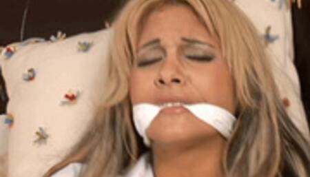 British beauty Carmel Moore is dressed in a tiny pink skirt, barely buttoned blouse, knee high socks and coils of rope!