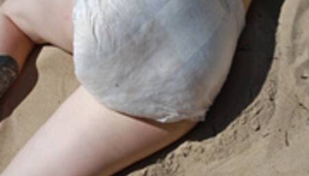 Nicole is sunbathing on the beach