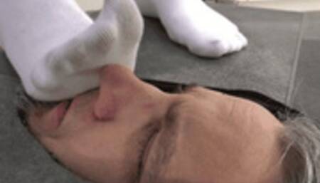Slave's face under stinky socks and painful boots