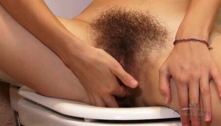 Mariana masturbates in the bathroom, fingering her hairy pussy and caressing her tits