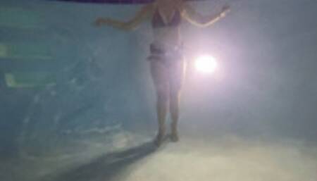 Underwater partial nudity in a public pool with old school weight belt and oval mask