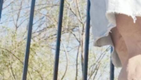 In jean skirt and tye dye sneakers