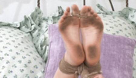Enticing blonde nude Justine Jolie rolls around on a bed cleave-gagged and hogtied, her dirty bare soles toed-tied!