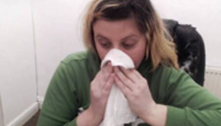 Sneezing into hanky in green hoodie