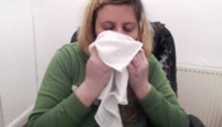 Nose blowing into hanky green hoodie