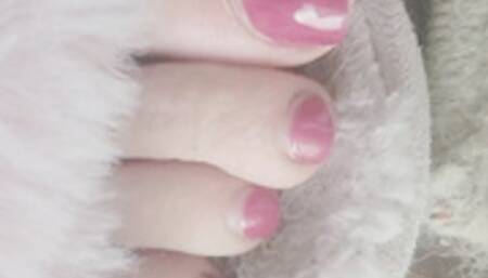 Pink fuzzy slippers and pink-red toes