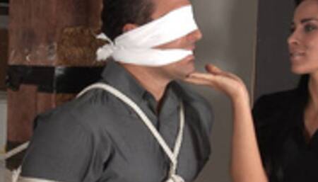 Big strong Luke is blindfolded and lead to a garage then tied to a post by gorgeous Laura Lee!