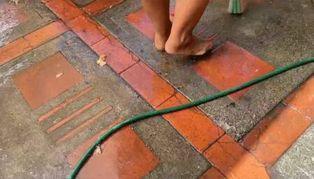Balbina sweeping and cleaning the backyard barefoot