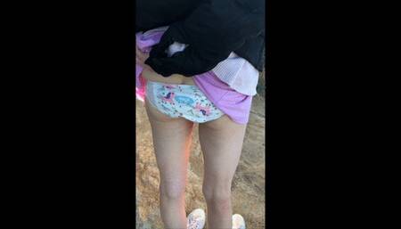 Peeing in my pull-up outdoors until it leaks on my socks!