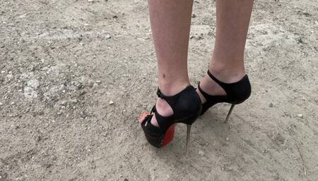 a girl in high heels pierces plastic, wood, bottles and other objects with her sharp heels
