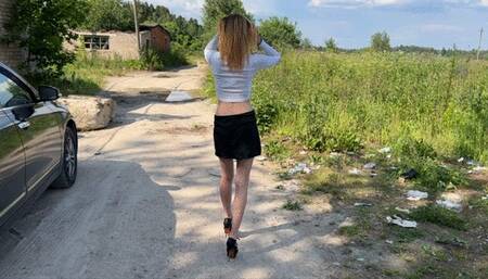 girl in high-heeled sandals walks through puddles and gets her toes and feet dirty