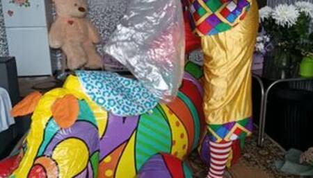 clown girl sit on rhino and blow myllar balloons